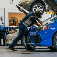 man working on Subaru in shop